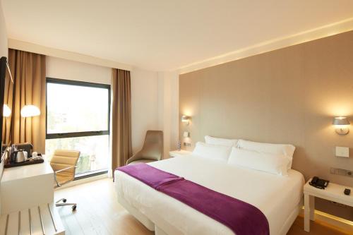 a hotel room with a large bed and a window at Sercotel Amistad Murcia in Murcia