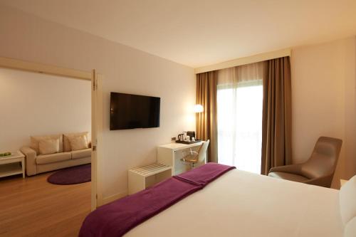 a hotel room with a bed and a couch at Sercotel Amistad Murcia in Murcia