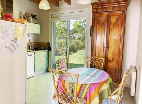 une cuisine avec une table, des chaises et un réfrigérateur dans l'établissement Maison familiale avec accès à la plage, à Mesquer