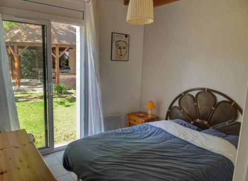 une chambre avec un lit et une grande fenêtre dans l'établissement Maison familiale avec accès à la plage, à Mesquer