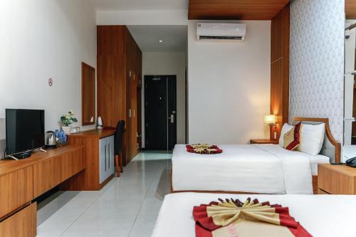 a hotel room with two beds and a television at KHÁCH SẠN SAO MAI in Cao Lãnh