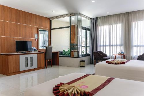 a hotel room with two beds and a television at KHÁCH SẠN SAO MAI in Cao Lãnh
