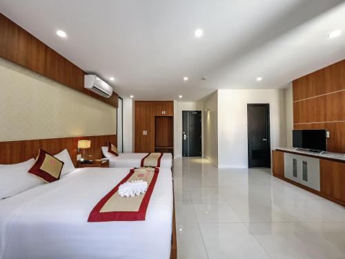 a hotel room with a large bed and a television at KHÁCH SẠN SAO MAI in Cao Lãnh