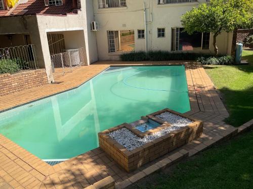 una piscina in un cortile con una casa di Royal Olympia Lodges & Safaris RSA a Sandton