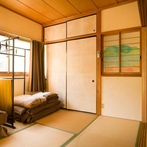 a bedroom with a bed and glass doors in it at Shared house Machiyado in gujo hachiman in Gujo