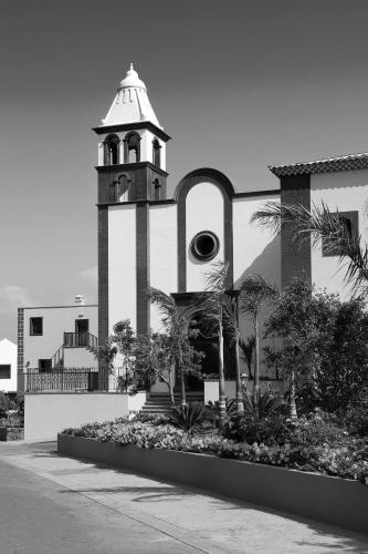a building with a clock tower on the side of it at Hotel Hacienda del Conde Meliá Collection Golf & Spa - Adults Only in Buenavista del Norte