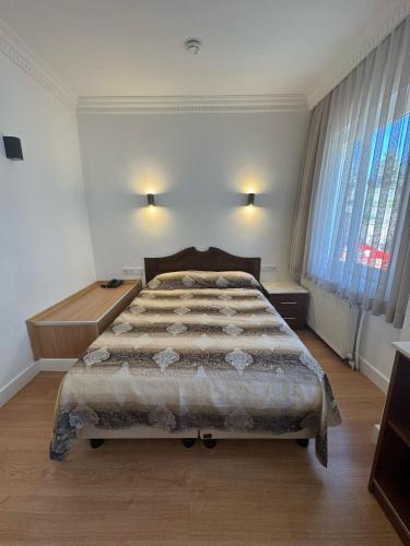 a bedroom with a large bed and two windows at Hanedan Hotel in Istanbul
