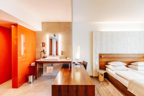 a hotel room with a bed and a sink at Das Seepark Wörthersee Resort in Klagenfurt
