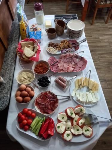 Una mesa cubierta con muchos tipos diferentes de comida en Gentiana-Sureanu, en Tău Bistra