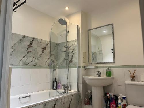 a bathroom with a shower and a sink at North Acton Flat in London