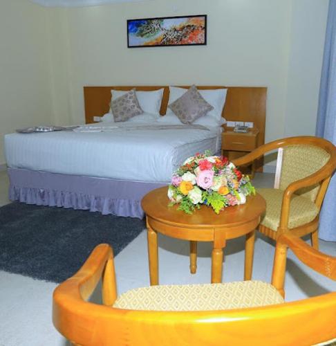a bedroom with a bed and a table and chairs at Amran hotel in Addis Ababa