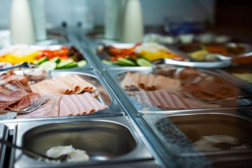 a buffet of food with meat and other foods at Hotel Garni Isarlodge Wiesenhof in Scharnitz