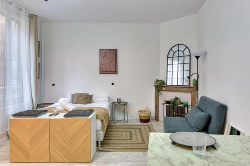 - un salon avec un lit et une chaise bleue dans l'établissement L'Écrin Normand un studio au cœur de Rouen, à Rouen