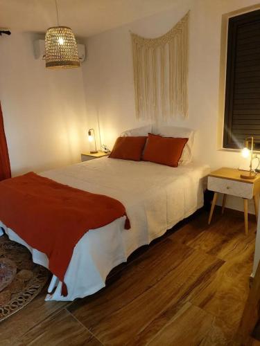 a bedroom with a large white bed with orange pillows at Villa élégante avec piscine privée à Saint Paul + Vue sur la mer in Saint-Paul