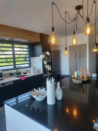 a kitchen with a counter with a vase of flowers on it at Villa élégante avec piscine privée à Saint Paul + Vue sur la mer in Saint-Paul