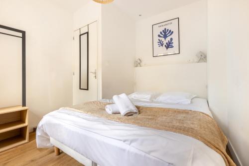 a bedroom with a bed with two towels on it at LA SUITE HUIT DU BRAS D'OR in Boulogne-sur-Mer