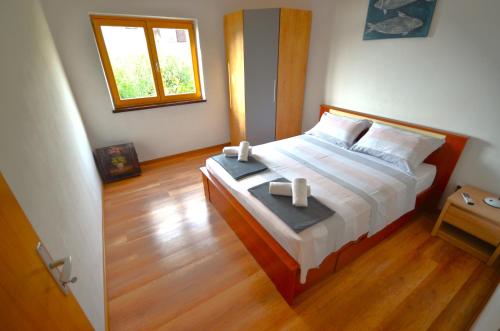 Un dormitorio con una cama grande con suelo de madera y una ventana. en Holliday house in Zatoglav, en Podglavica