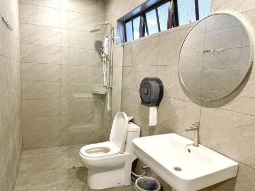 a bathroom with a toilet and a sink and a mirror at ALEXIS VILLA Whole OR Room in Muar