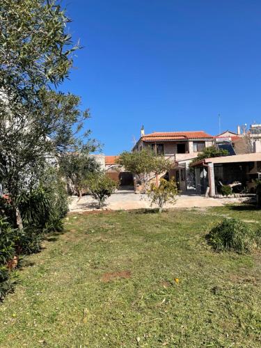 a yard with a house in the background at Aroma Avlis Apartments in Areopolis