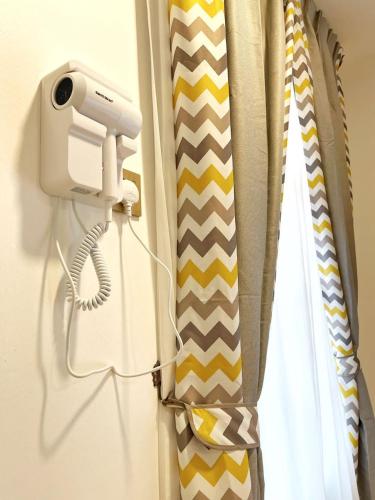 a hair dryer and ties hanging on a window at ALEXIS VILLA Whole OR Room in Muar