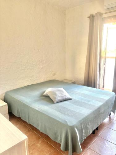 a bedroom with a bed with a pillow on it at Nura Bilo 2 in San Teodoro
