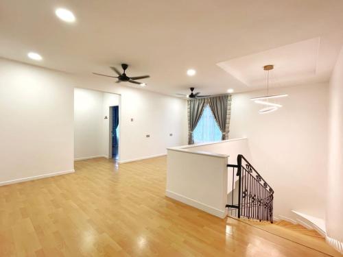 an empty living room with a ceiling fan and wooden floors at ALEXIS VILLA Whole OR Room in Muar