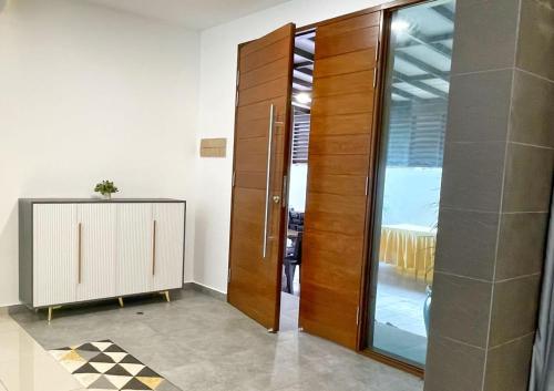 a room with a wooden cabinet and a glass door at ALEXIS VILLA Whole OR Room in Muar