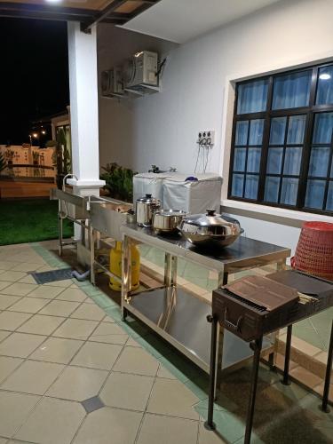 a kitchen with pots and pans on a table at ALEXIS VILLA Whole OR Room in Muar