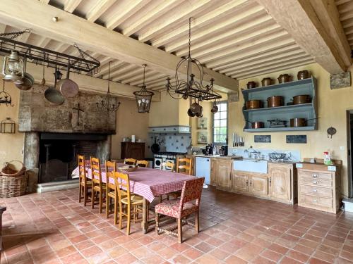 a kitchen with a table and chairs and a fireplace at Domaine Labattut in Saint-Astier