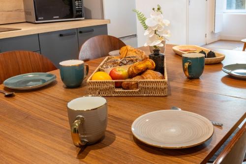 a table with a basket of bread and fruit on it at LA SUITE SEPT LE BRAS DOR in Boulogne-sur-Mer