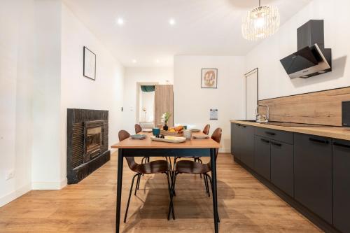 a kitchen with a table and chairs and a fireplace at LA SUITE SEPT LE BRAS DOR in Boulogne-sur-Mer