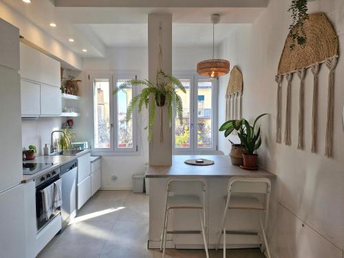a kitchen with white cabinets and a table and chairs at Stazione Rooms in Quarto dʼAltino