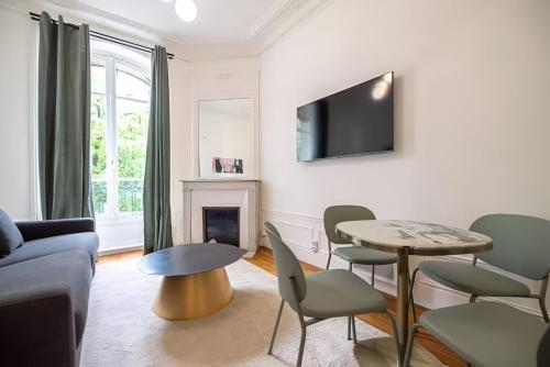 - un salon avec une table, des chaises et une télévision dans l'établissement TBS 316 - Apartment close to Eiffel Tower, à Paris