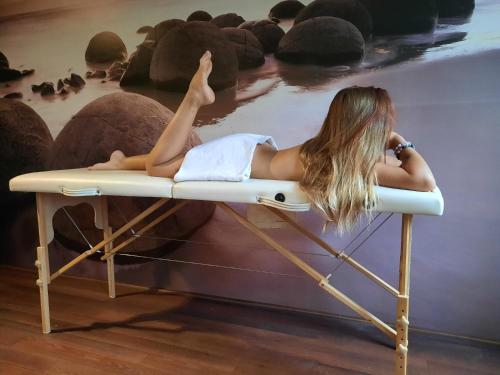 a woman laying on a table next to the water at Hotel u Budvaru in České Budějovice
