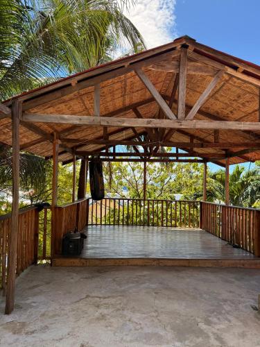 a wooden pergola on a patio with a palm tree at Villa-Atlas Guest House in Malapascua Island