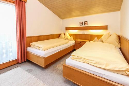a bedroom with two beds and a window at Gästehaus Rass in Lofer
