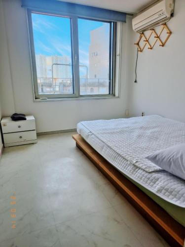 a bedroom with a bed and a large window at Mamas and Papas Guesthouse and Apartments in Seoul in Seoul