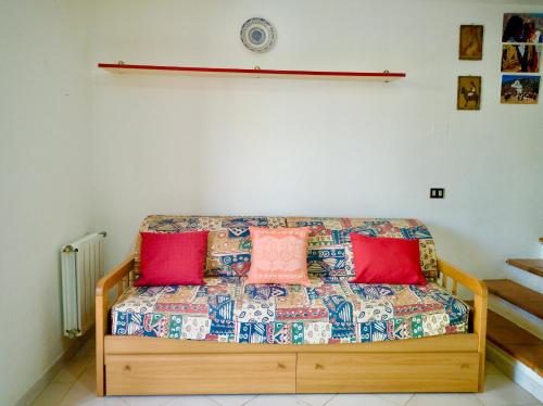 a couch in a room with red pillows on it at Villetta a pochi passi dal mare in Àrbatax