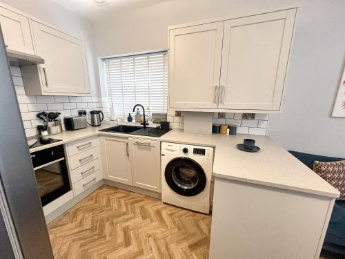 una cocina con lavadora y secadora en una encimera en Merton Place, Southsea apartment with parking, en Southsea