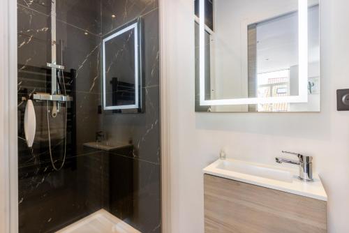a bathroom with a shower and a sink at Le Bras d'or Apparts et Spa in Boulogne-sur-Mer