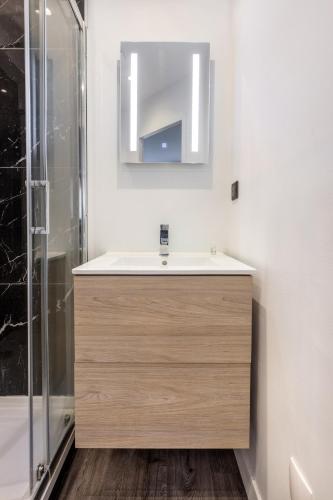 a bathroom with a sink and a shower at Le Bras d'or Apparts et Spa in Boulogne-sur-Mer