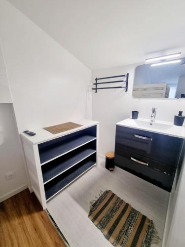 La salle de bains blanche est pourvue d'un lavabo. dans l'établissement Jolie maison rénovée avec jardin, à Esnandes