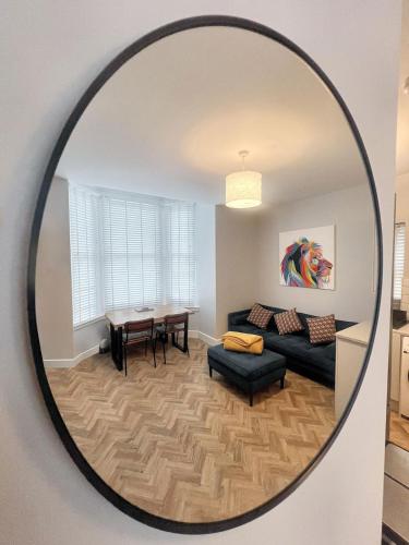 a mirror in a living room with a couch and a table at Merton Place, Southsea apartment with parking in Southsea