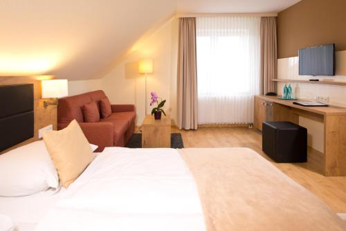 a hotel room with a large bed and a couch at Spreewaldhotel Stephanshof in Lübben