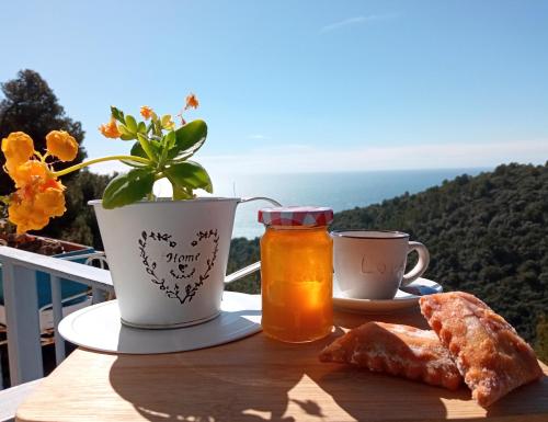 een tafel met brood en een kopje thee en een bloem bij Message in a Bottle Bed and Breakfast in Camporosso