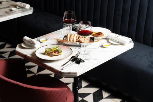a table with plates of food and glasses of wine at The Goethe Hotel - Small Luxury Hotels of the World in Rome