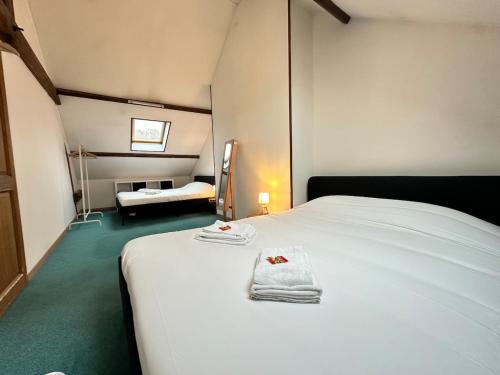 une chambre avec un lit blanc avec des serviettes dessus dans l'établissement S Albert poulain T3 tout équipé proche Charleville, à Nouzonville