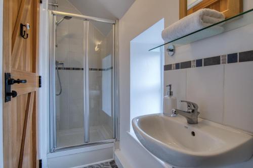 a bathroom with a sink and a shower at Bunk House - 4 Bedroom - Llangenith in Llangennith