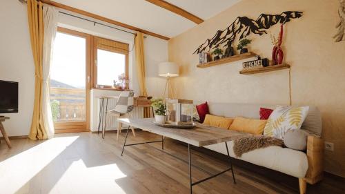 a living room with a couch and a table at Kuschel Alpin Apartment & Traumblick Nockberge auf H1200m in Plessnitz