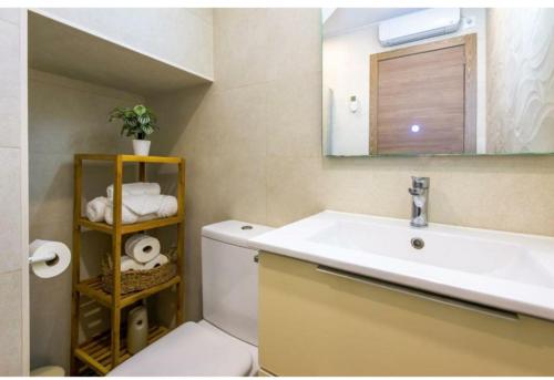 a bathroom with a sink and a toilet and a mirror at Lolena Calas De Torrevieja in Torrevieja
